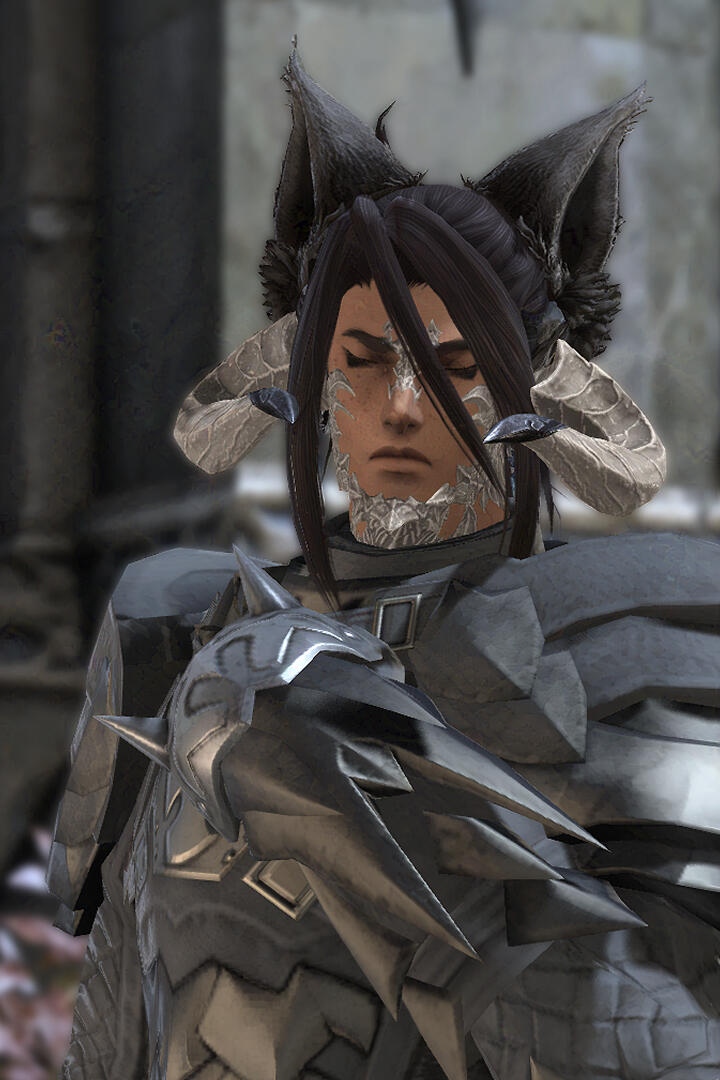 Cinnamon, a Miqo'ra with long dark brown hair and tan skin, looking solumn as they stand in front of the Fortemps Manor, wearing their Dark Knight attire.